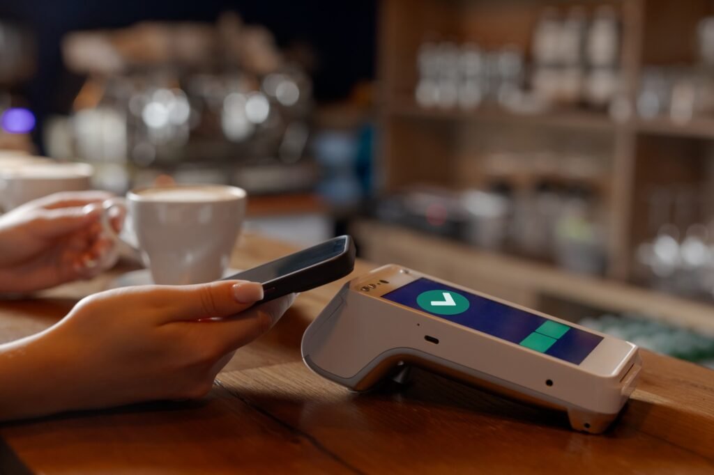 customer makes contactless NFC payment by phone through terminal in cafe, concept successful payment